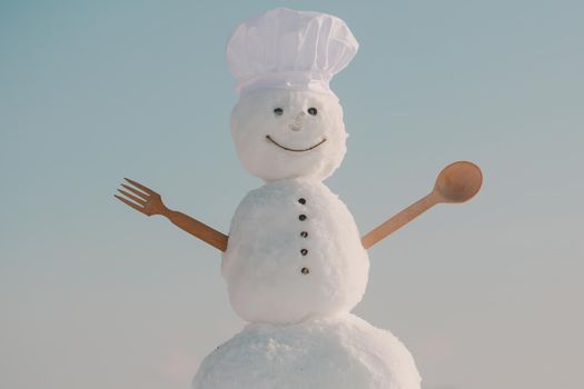 Snowman chef in winter with kitchen spoon. Christmas food cooking. Xmas or christmas cooking