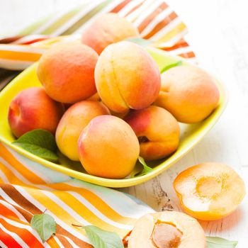 Fleshy apricots in the bowl on the table