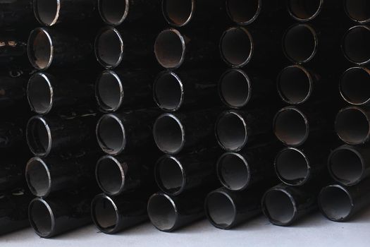 Black metal pipes for gasification or water supply. Industrial background close up.