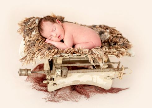 Sweet naked newborn lying on retro scales