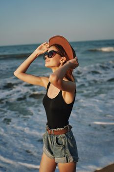 woman walking on the beach hat travel vacation sun. High quality photo