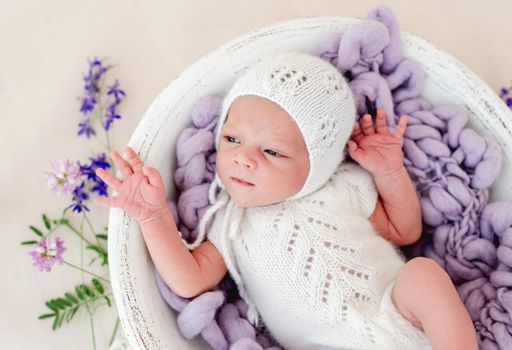 Sleeping newborn baby girl in lilac bodysuit