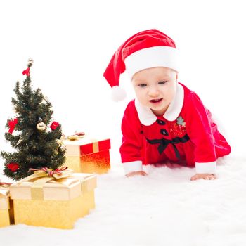 Santa baby girl with gift box and christmas decorations on a fur