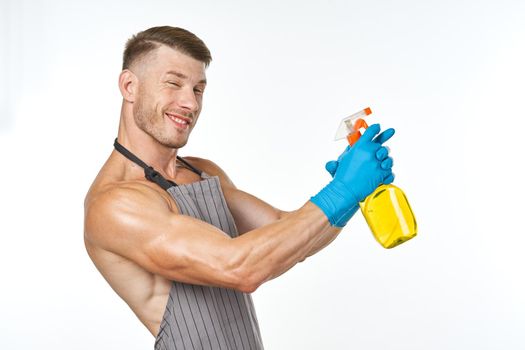 man in apron detergent cleaning service light background. High quality photo