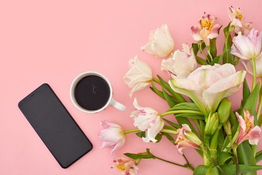 White cup of coffee with tulip and smartphone on pink background copy space