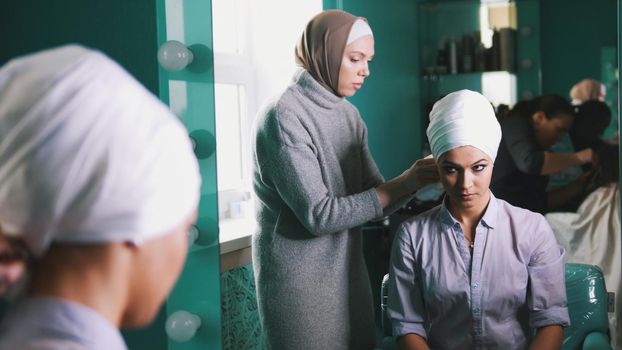 Muslim woman preparing islamic wedding headdress for the beautiful bride, close up