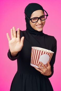 Muslim woman entertainment cinema popcorn fashion purple background. High quality photo