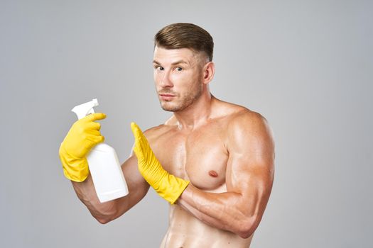 man with pumped muscles detergent posing cleaning. High quality photo