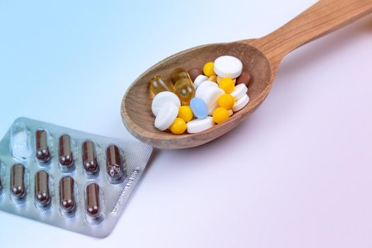 Medicine, pills and drug in wood spoon on white background with copy space.