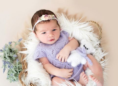 Portrait of lovely newborn girl with open eyes and mouth