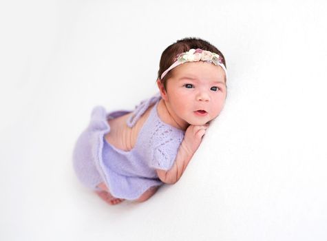 Portrait of lovely newborn girl with open eyes and mouth
