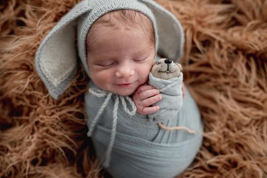 Portrait of smiling in dream newborn in funny knitted hat