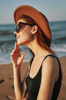 pretty woman in hat and sunglasses on the beach walk sun. High quality photo