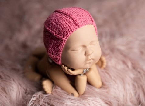 Plastic mannequin of baby, made for posing, in frog stand, isolated