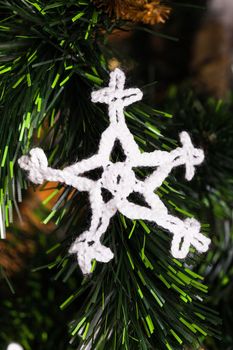 Knitted white snowflake on the christmas tree