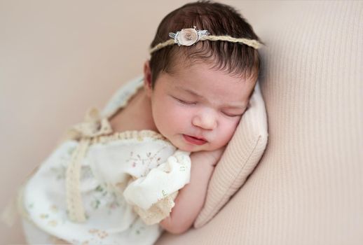 Nice newborn hugging toy sleeping on side on tiny pillow