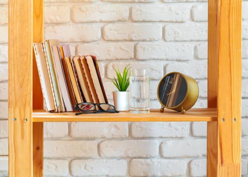 Wooden rack shelf with home decor stuff. Close up.