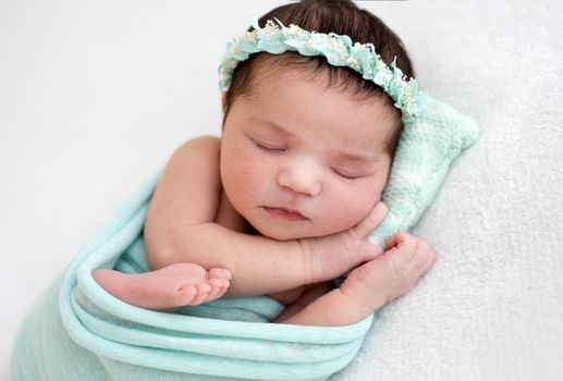 Cute newborn sleeping peacefully on tiny pillow