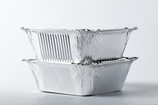 Foil food box with takeaway meal on white background close up