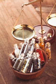Little bottles with spices in a wooden bowl in the kitchen. Retro decorations