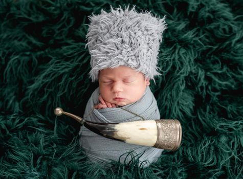 Newborn in costume of steppe warrior with drinking horn