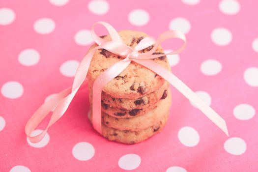 Cookies with ribbon. Holiday present on pink polka dot textile