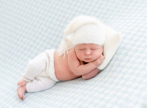 Charming newborn resting on side with tiny pillow under head