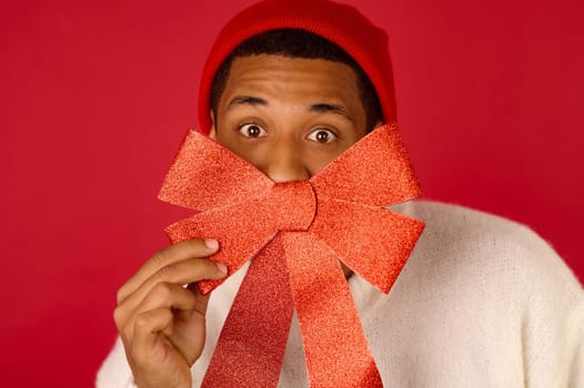 Festive mood. A young dark-skinned man in santa hat feeling joyous