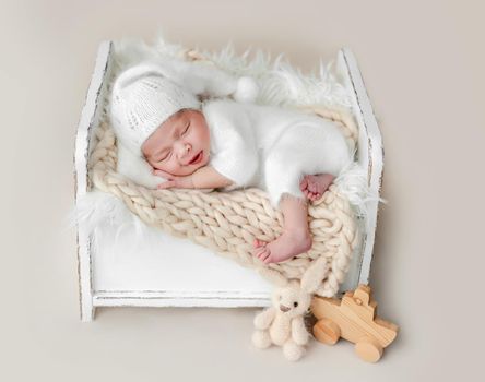 Beautiful newborn baby girl sleeping on tiny bed