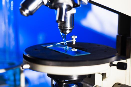 Microscope glass with liquid in pipette for research, close up view