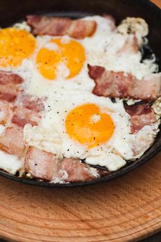 Fried bacon and eggs on the pan - rusty breakfast