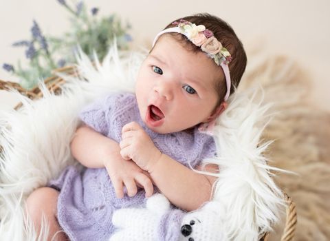 Portrait of lovely newborn girl with open eyes and mouth