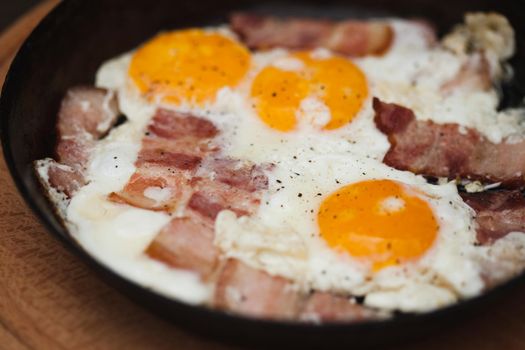 Fried bacon and eggs on the pan - rusty breakfast