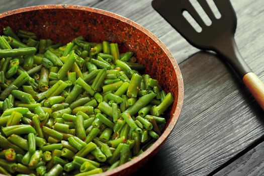 Vegetarian food. Fried string beans in a pan. Stylish background for design. Minimalism. Healthy food from vegetables