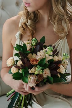 Woman in beautiful dress holding flower bouquet in hands