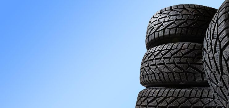 Winter car tires. Group of tires for winter driving on a blue background.