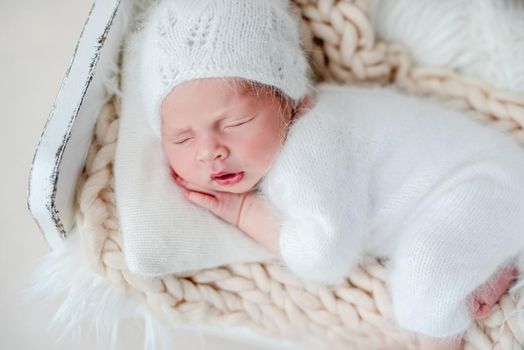 Beautiful newborn baby girl sleeping on tiny bed