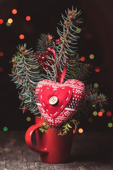 Handmade knitted heart - christmas decoration on the fir branch