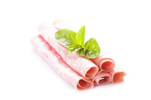 Ham slices isolated on white with green basil leaves