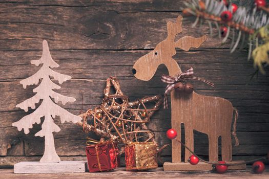 Natural christmas decor - deer and fir tree over wooden background