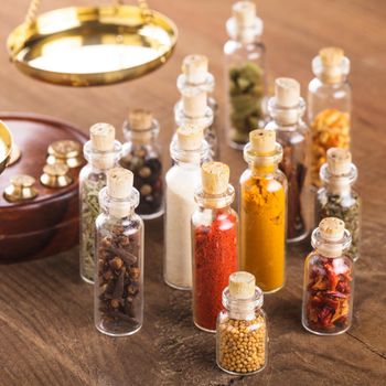 Little bottles with spices and scales on the table