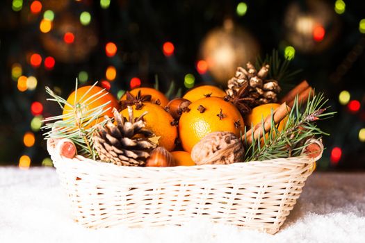 Christmas basket - fir, tangerins and spices on the snow