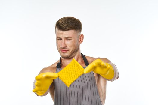 a man in a gray apron wearing rubber gloves cleaning washing. High quality photo