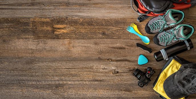 Top view of trekking equipment in corner on wooden background with copy space, top view