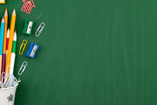 Stationery Pencils paper clip pen eraser in a white bucket. Still life on green school board background. Copy space Flat lay Top view Concept Education.