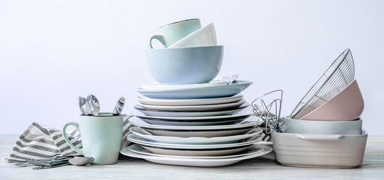 Top view on clean kitchenware and dishcloth on white table