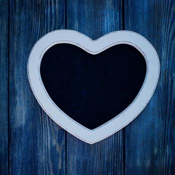 Heart shape chalkboard on the blue wooden wall