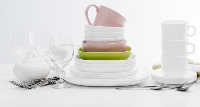 Pile of colourful square dishes and cups with dishcloth