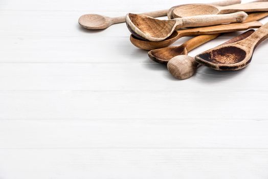 Big wooden natural spoons on white wooden background with free space for text, copyspace