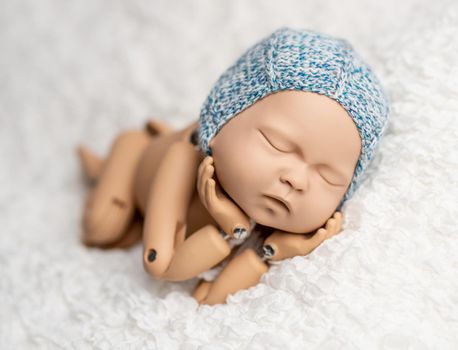 Precisely accurate mannequin of newborn in a hat for photo practicing